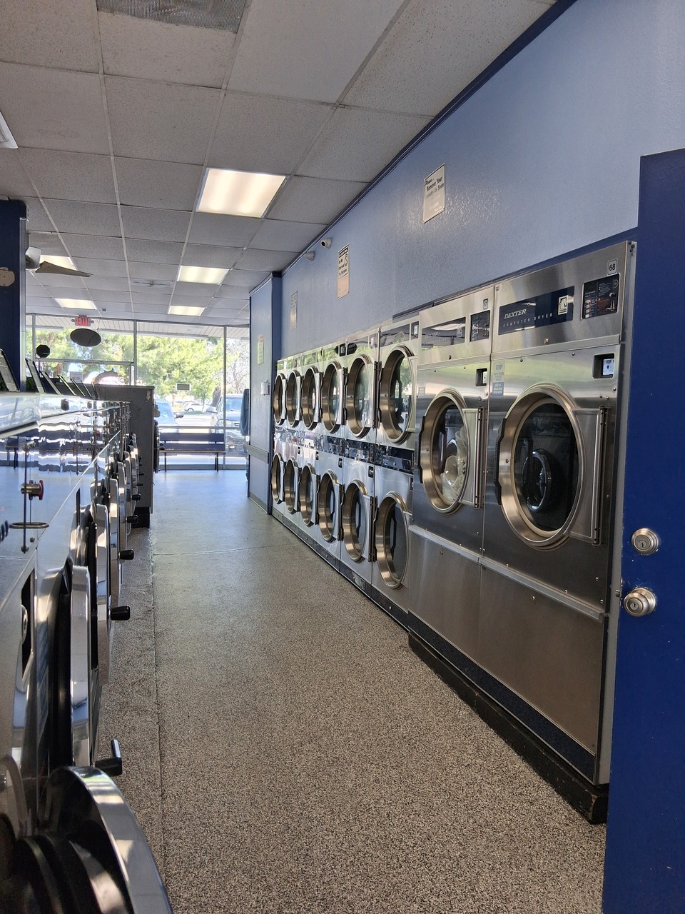Long row of coin operated laundry washers at a clean, well-maintained laundromat in Hemet, CA