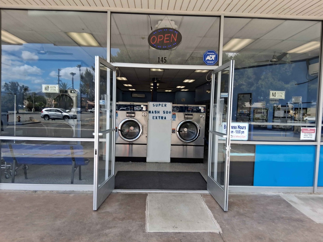 Front entrance to The Laundry Basket laundromat in Hemet, CA with open doors and washers visible inside Front entrance to The Laundry Basket laundromat in Hemet, CA with open doors and washers visible inside